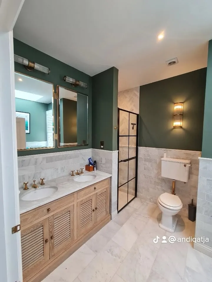 Finished en-suite bathroom with forest-green walls, double oak vanity, brass taps and black-framed shower enclosure